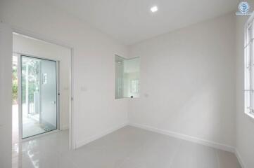 Bright and spacious empty room with large windows and glass door leading to the garden