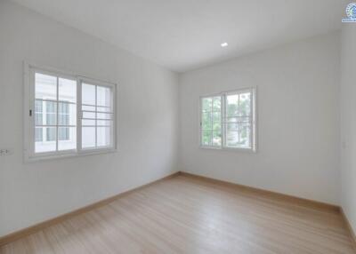 Spacious empty bedroom with large windows and hardwood floors