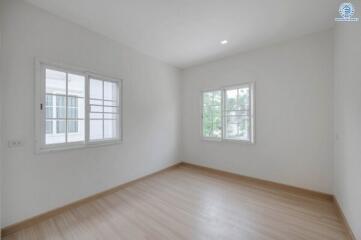 Spacious empty bedroom with large windows and hardwood floors