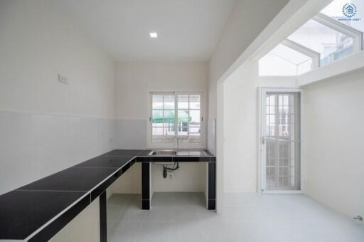 Modern minimalist kitchen with high ceiling and natural light