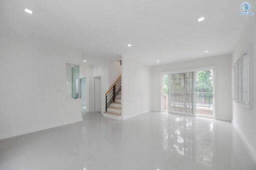 Spacious living room with natural light and modern staircase