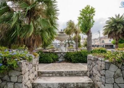 Elegant garden with fountain surrounded by lush greenery and flowers