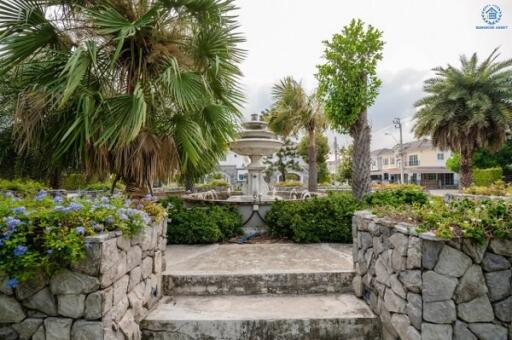 Elegant garden with fountain surrounded by lush greenery and flowers