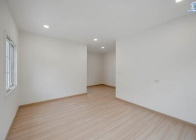 Spacious empty bedroom with wooden flooring and natural light