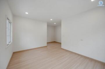 Spacious empty bedroom with wooden flooring and natural light