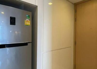 Modern kitchen with stainless steel refrigerator and wood-paneled door