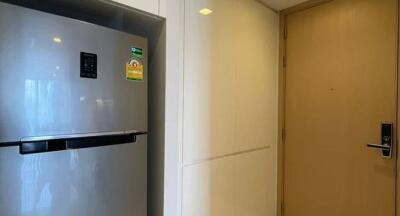 Modern kitchen with stainless steel refrigerator and wood-paneled door