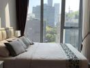 Elegant bedroom with a large bed, city view, and plush bedding