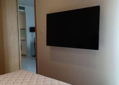 Modern bedroom with wall-mounted television and wooden door