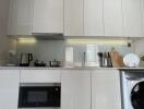 Modern kitchen interior with white cabinetry and built-in appliances