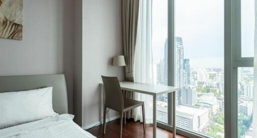 Modern bedroom with large windows offering city views