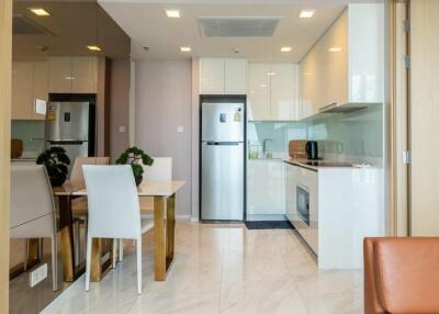 Modern kitchen with integrated dining area opening into a bright living space