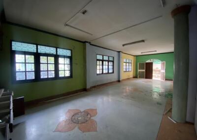 Spacious empty room with decorative flooring and multiple windows