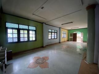 Spacious empty room with decorative flooring and multiple windows