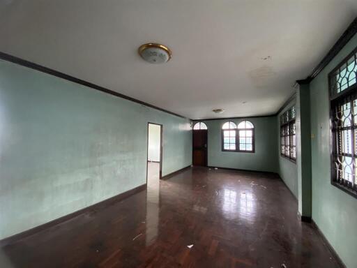 Spacious empty living room with wooden floors and large windows