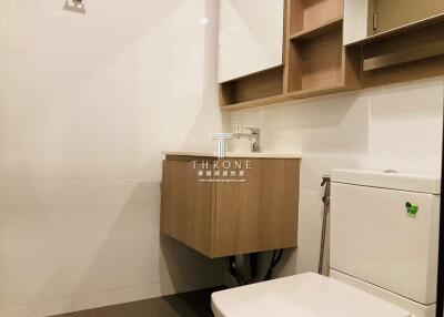 Modern compact bathroom with wood accented cabinets and white interiors