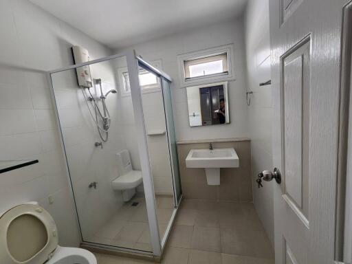 Spacious modern bathroom with glass shower enclosure and white fixtures