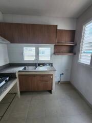 Compact kitchen with wooden cabinets and tiled flooring