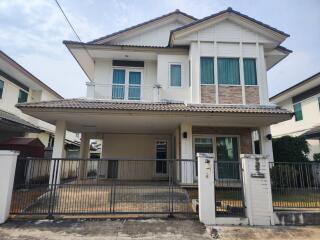 Modern two-story house front view with gated entrance