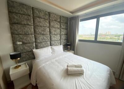 Spacious bedroom with large window and stylish wall paneling
