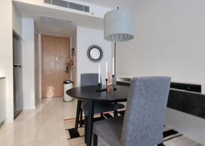 Modern kitchen with dining area featuring marble countertops and stylish lighting