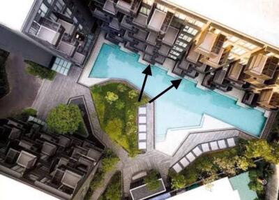 Aerial view of a residential complex with a centrally located swimming pool surrounded by apartment units