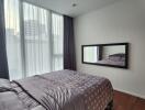 Modern bedroom with city view through large windows