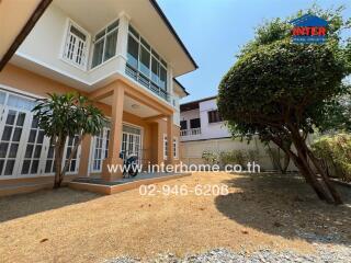 Spacious two-story house with large windows and landscaped front yard