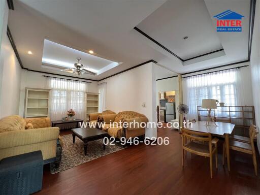 Spacious and well-lit living room with elegant furniture and dining area