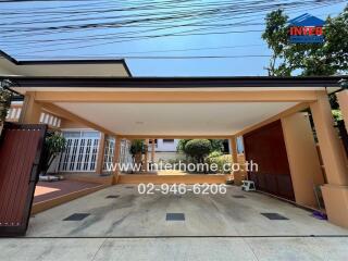 Spacious driveway of a residential home with covered carport and secure gate