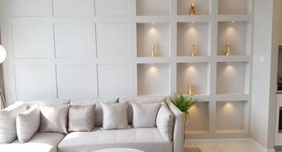 Modern living room with elegant white sofa and built-in shelving units