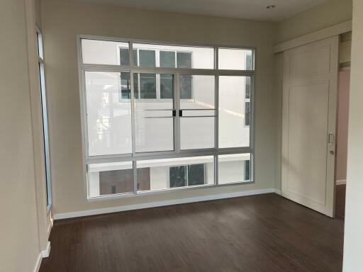 Empty bedroom with large windows and wooden floor