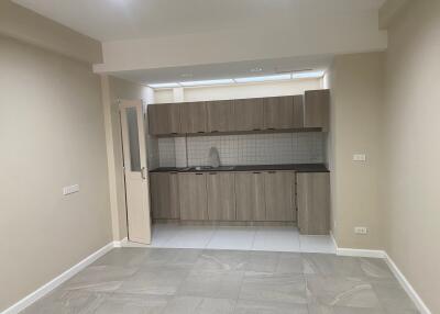 Modern kitchen with light wood cabinetry and tile flooring