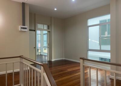 Spacious upper floor living area with hardwood flooring and balcony access