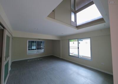 Spacious living room with large windows and skylight