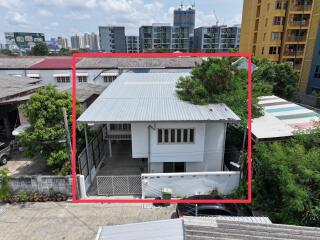 Exterior of a two-story building with a white facade and a metal roof