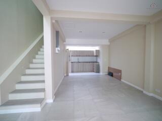 Modern open-concept living area with staircase and kitchen