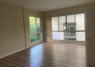 Spacious living room with large windows and wooden floor