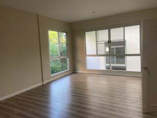 Spacious living room with large windows and wooden floor