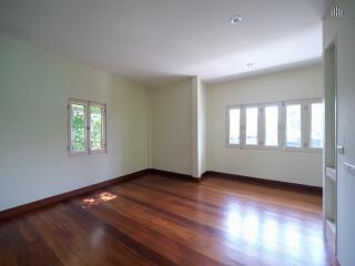 Spacious living room with large windows and wooden floor