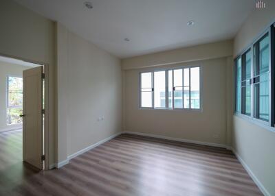 Spacious living room with large windows and wooden flooring