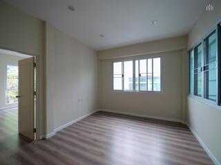 Spacious living room with large windows and wooden flooring