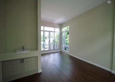 Spacious living room with large windows and wooden flooring