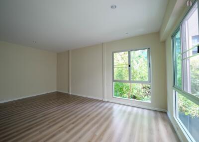 Bright and spacious living room with large windows and wooden flooring