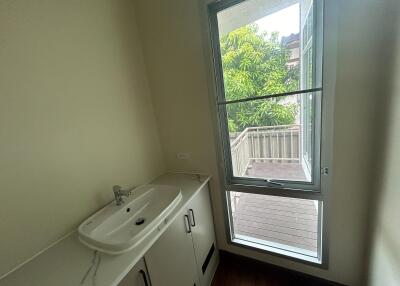 Bathroom with wide sink area and window overlooking a balcony