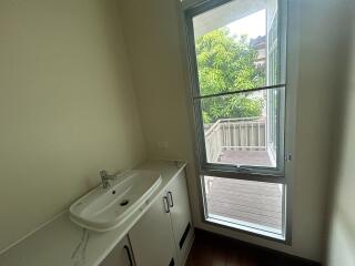 Bathroom with wide sink area and window overlooking a balcony