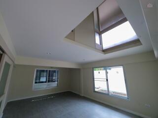 Spacious living room with large windows and ceiling skylight