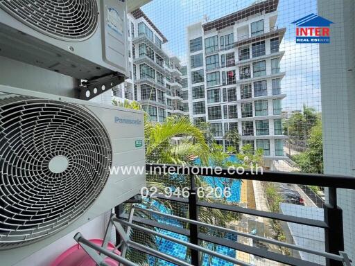 Modern city view balcony with air conditioning units and lush greenery