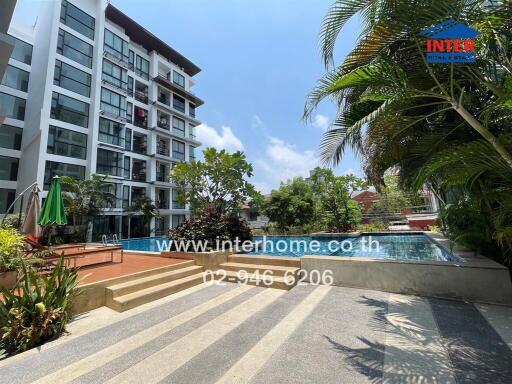 Modern residential building with a communal swimming pool and lush greenery