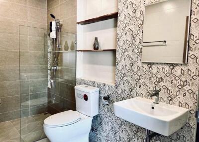 Modern bathroom with patterned tiles and chrome fixtures